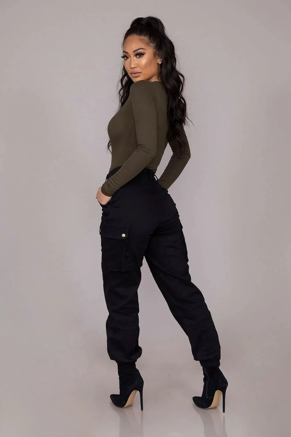 "Upgrade your style with these chic high-waisted black cargo pants featuring button pockets and a gothic twist. These solid color, long trousers are perfect for all sizes. Get yours now!"